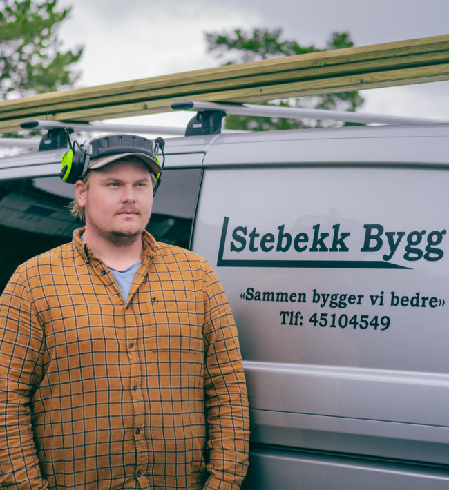 Tømrer Fredrik Stebekk foran firmabilen til Stabekk Bygg AS